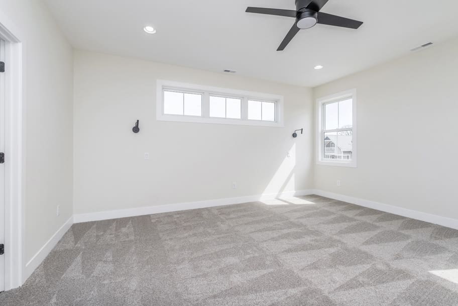 Primary Bedroom: A spacious room with carpet and a ceiling fan.