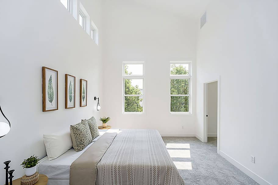 Bright and Airy Primary Bedroom with White Walls and Abundant Windows