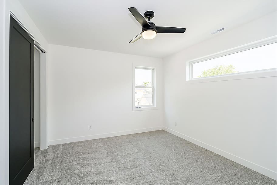 Additional Bedroom with Black Sliding Door Closet and Black Ceiling Fan