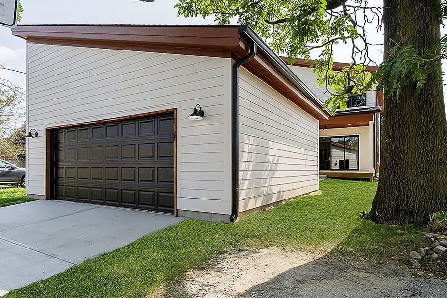 Exterior of Detached Garage with Black Door, Cream Siding, and Black and Brown Accents by Gem Homes Indianapolis