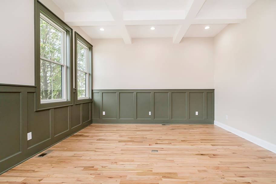 Dining Room with Coffered Ceiling and Green Wainscoting Accent Wall in a New Construction Home by Gem Homes Indianapolis