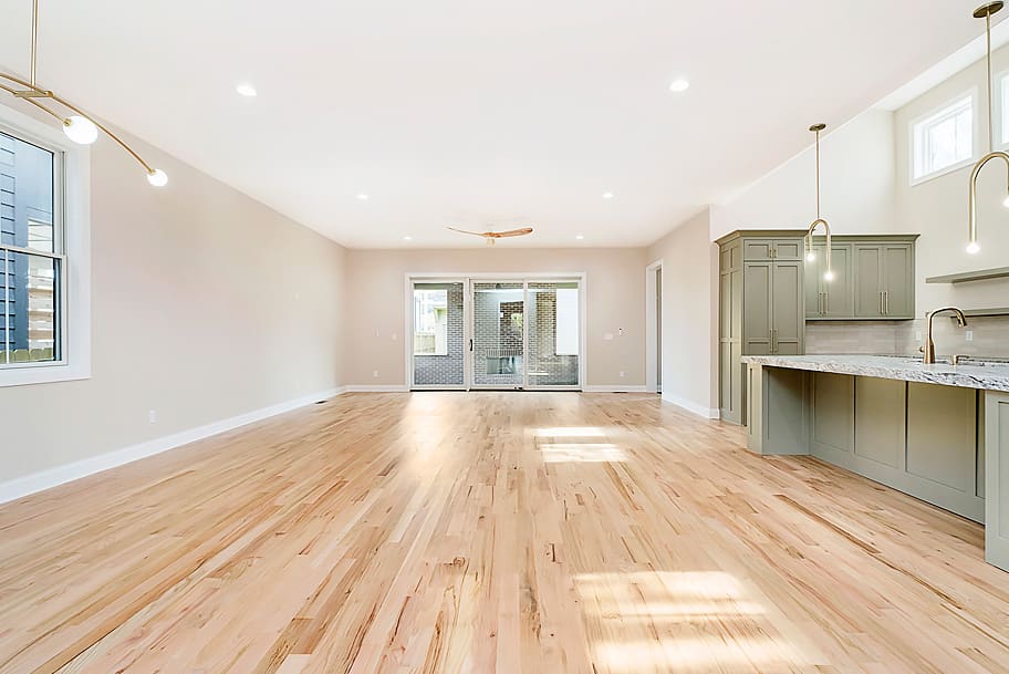 Open Concept Living Room with Light Wood Floors and Bi-Fold Doors in a Modern Home by Gem Homes Indianapolis