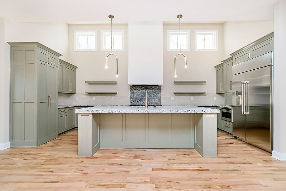 Kitchen with Olive Cabinets, Granite Countertop, and Large Island in a Custom Home by Gem Homes Indianapolis