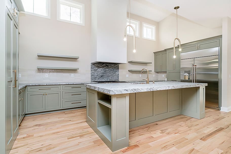 Kitchen with Olive Cabinets, Granite Countertop, Large Island, and Open Shelving in a Custom Home by Gem Homes Indianapolis