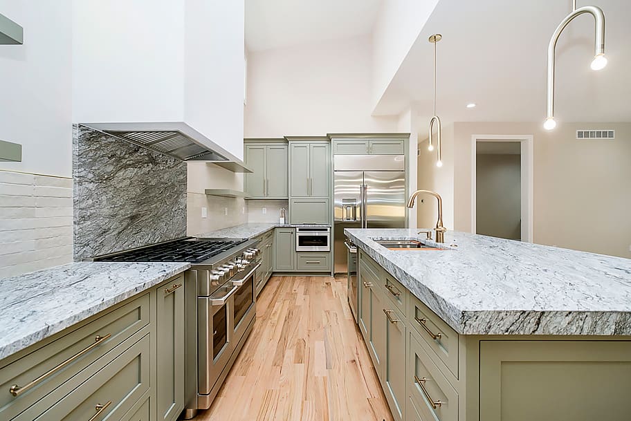 Close-Up of Kitchen with Granite Stone Backsplash Under Oven Area and Olive Cabinets in a Custom Home by Gem Homes Indianapolis