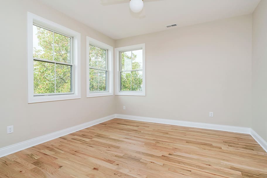 Guest Bedroom with 3 Windows and Light Wood Flooring in a Custom Home by Gem Homes Indianapolis