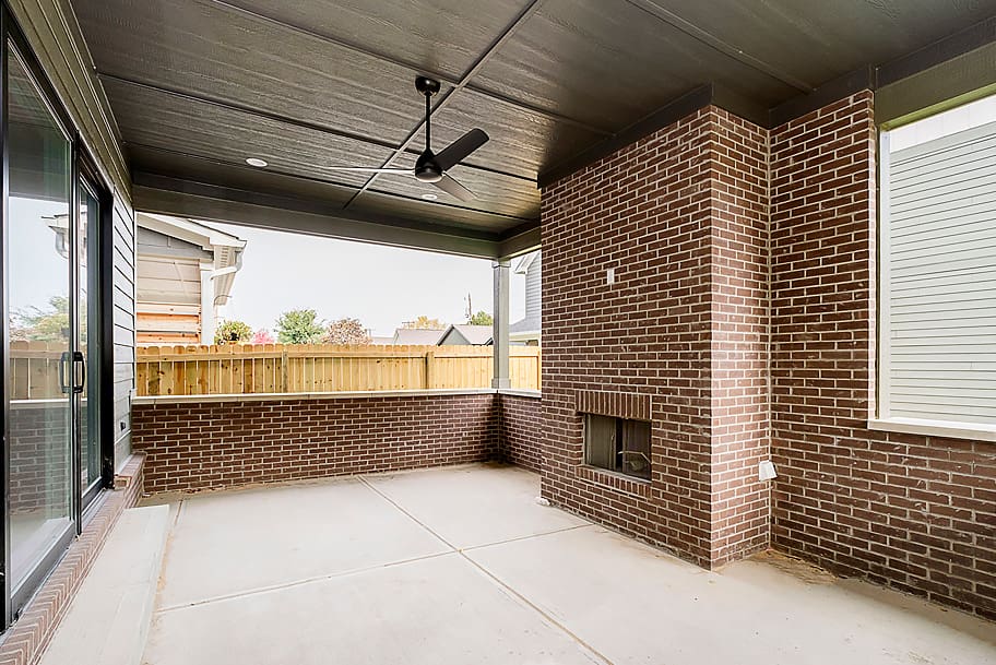 Covered Porch with Ceiling Fan and Brick Fireplace in a Custom Home by Gem Homes Indianapolis