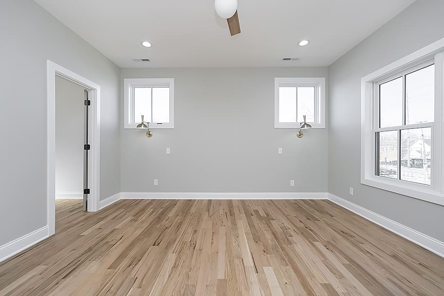 Primary Bedroom with Gray Walls and Wall-Mounted Bedside Lights in a Custom Home by Gem Homes Indianapolis