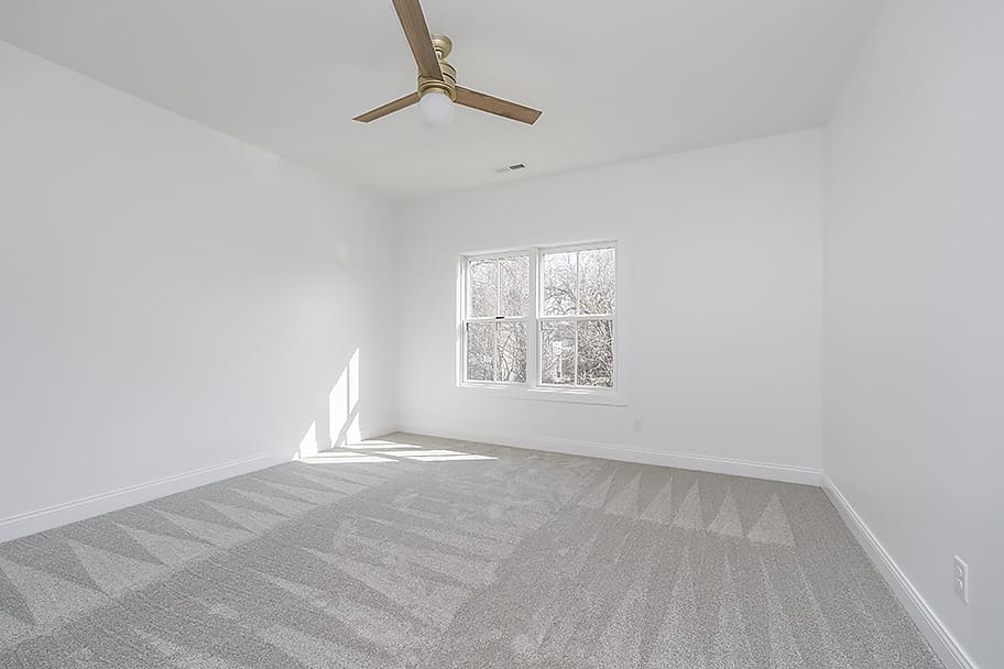 Guest Bedroom with Carpet and Wooden Ceiling Fan in a Custom Home by Gem Homes Indianapolis