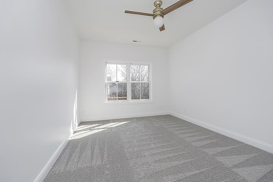 Guest Bedroom with Carpet and Wooden Ceiling Fan in a Home by Gem Homes Indianapolis