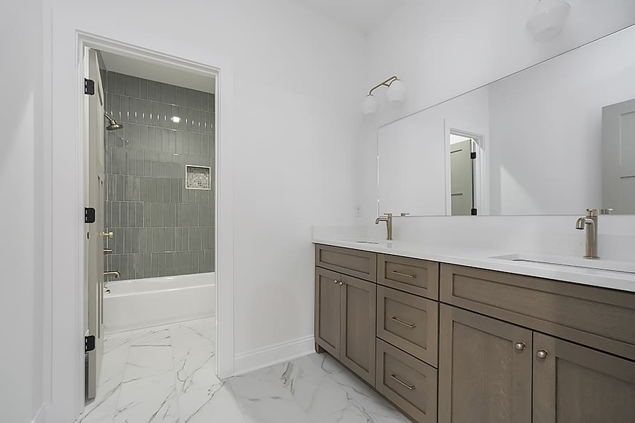 Guest Bathroom with Double Sinks, Green Tile Shower and Bathtub in Custom Home by Gem Homes Indianapolis