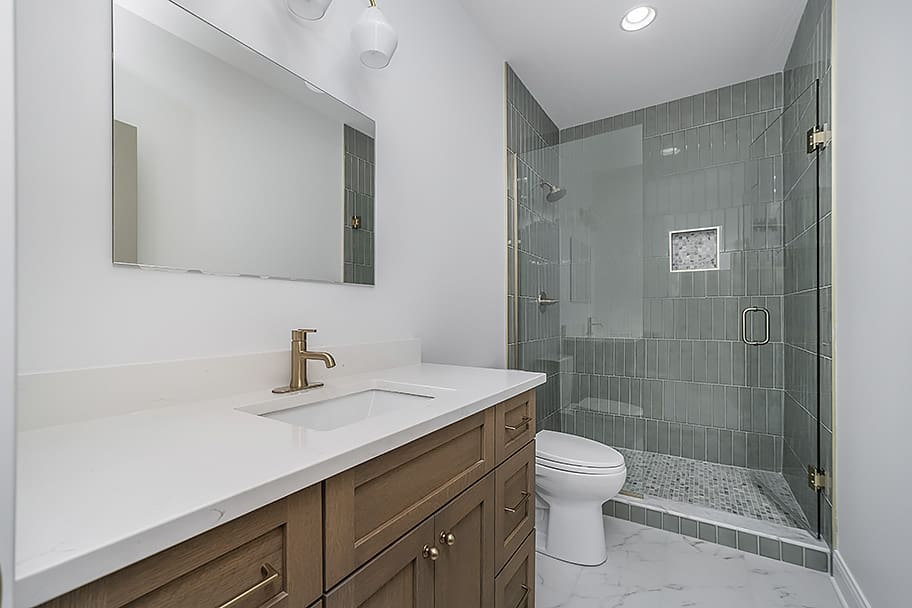 Guest Bathroom with Green Tile and Glass Shower Doors